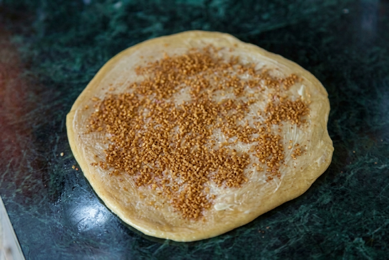 Нанесение сливочного масла и коричного слоя
